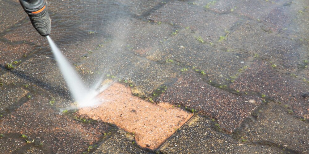 Professional pressure washing service removing dirt and grime from a concrete driveway in Florida. High-pressure water blasts away stains, revealing a clean and refreshed surface.